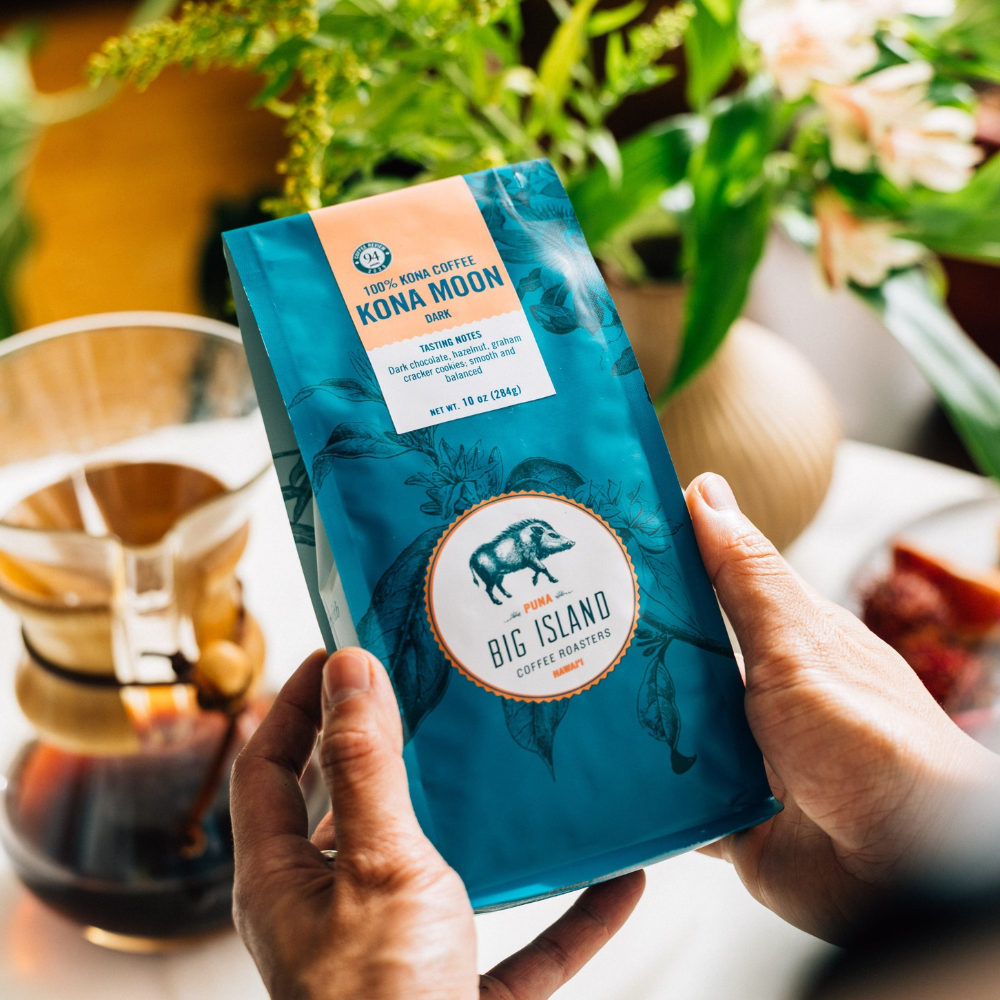 holding a bag of kona dark roast coffee moon